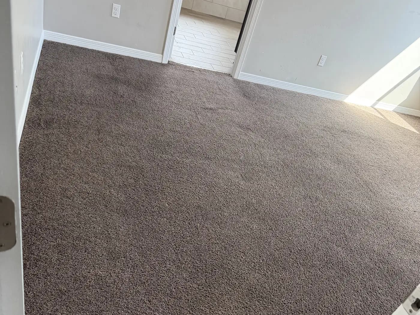 The same bedroom carpet lying flat after a re-stretch with a power stretcher