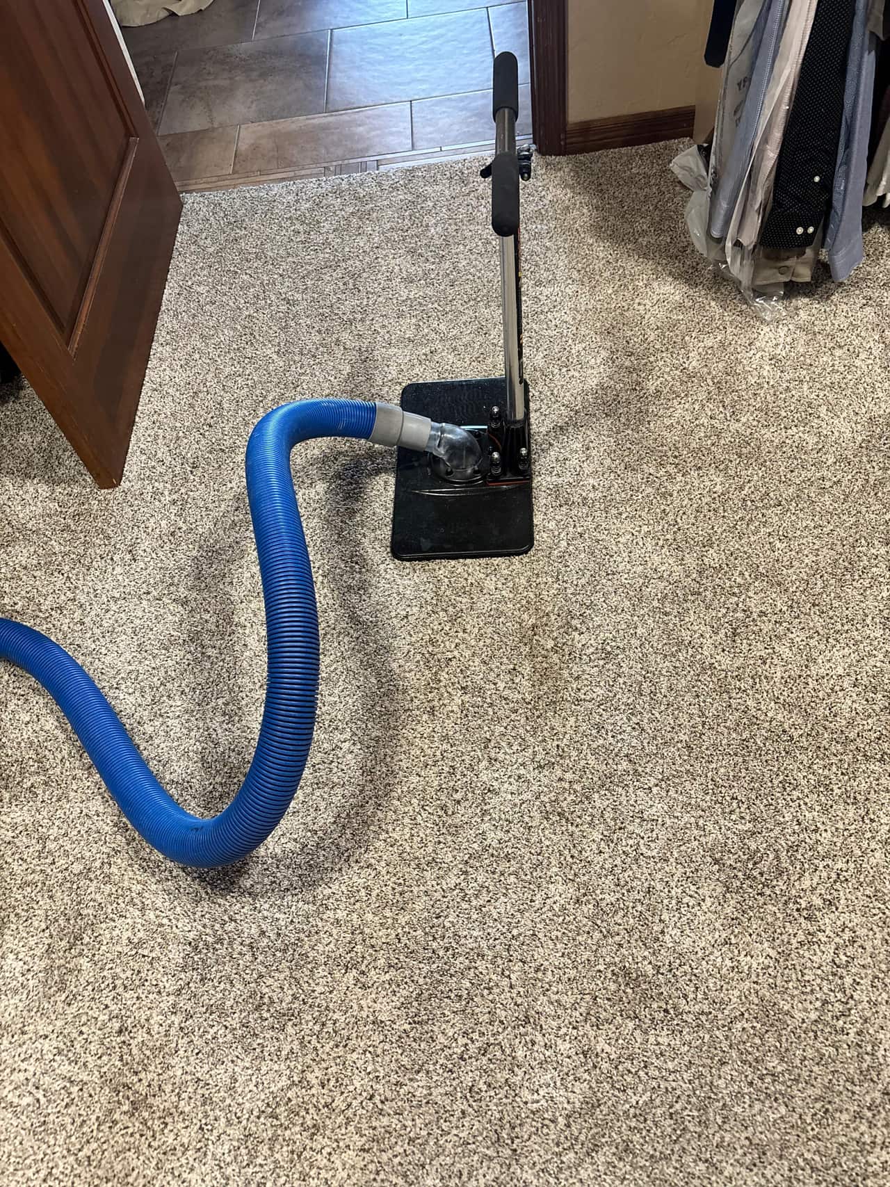 Hot water extraction carpet cleaning on a room floor during a carpet cleaning job in Las Cruces, NM