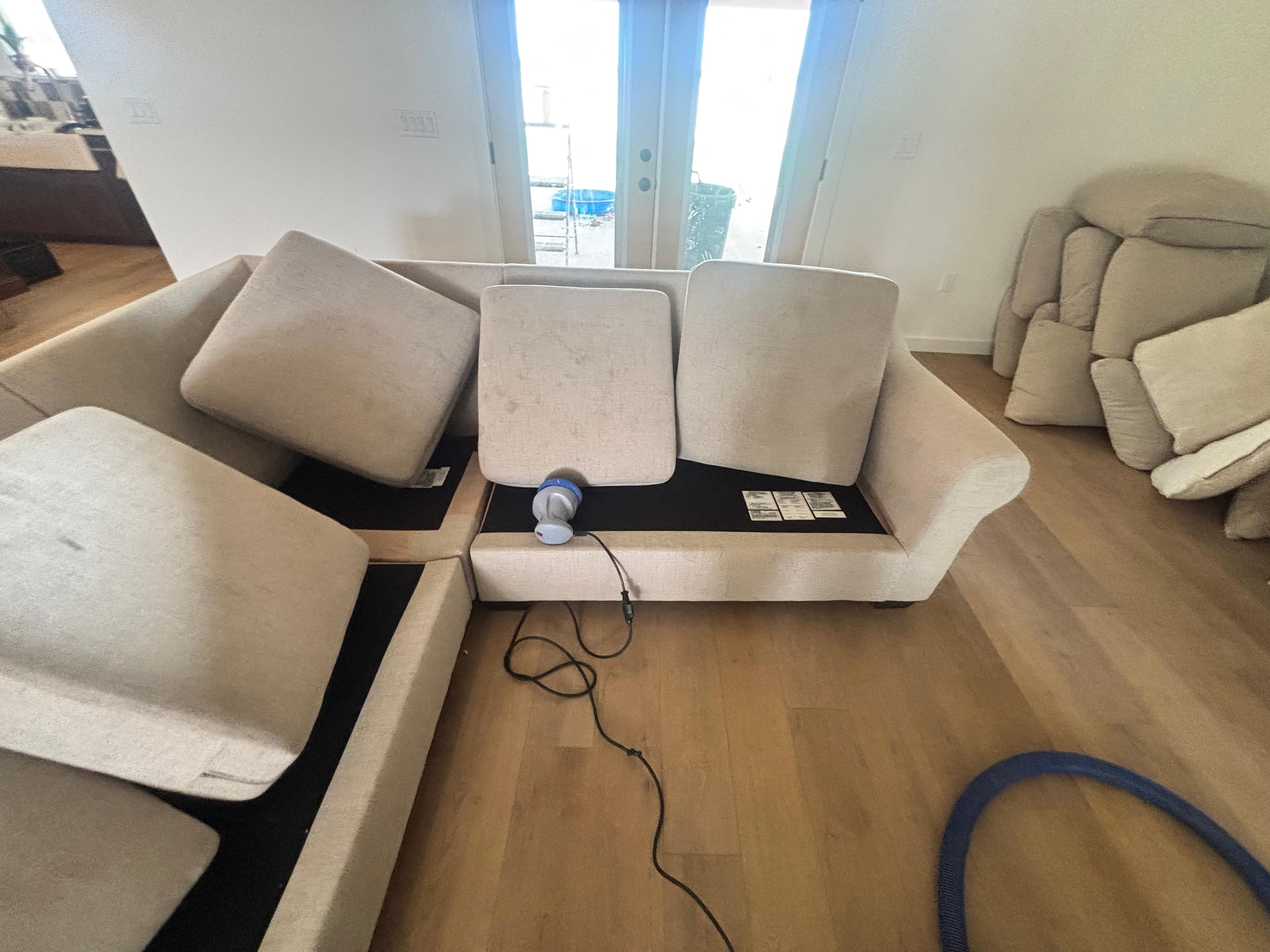 Sectional sofa with cushions lifted for upholstery cleaning during a furniture cleaning job